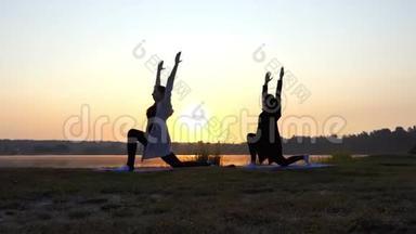 超级日落和女人做勇士2瑜伽运动在湖岸